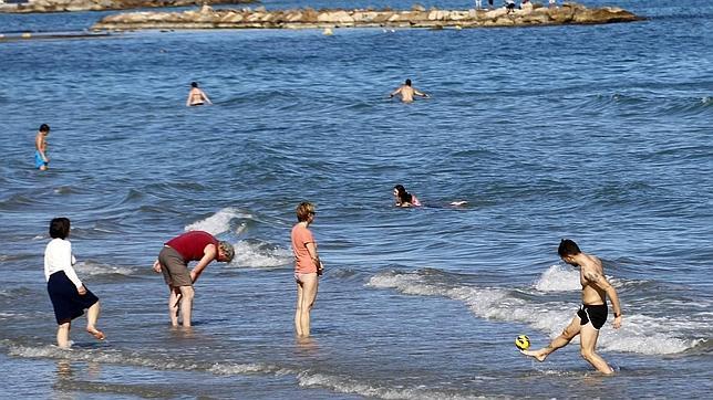 Las altas temperaturas han llenado hoy la playa de El Postiguet de Alicante
