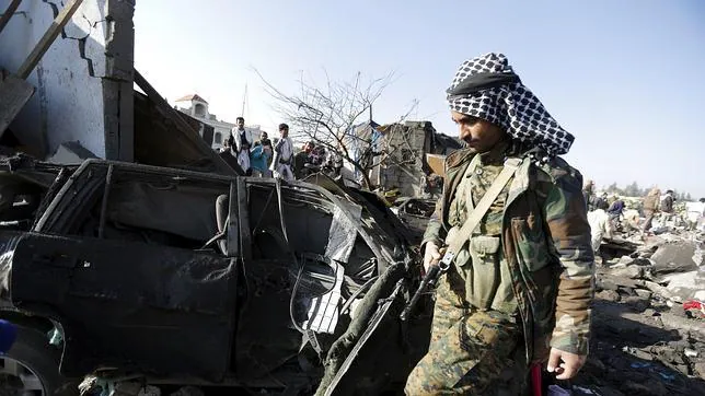 Un rebelde hutí junto a posiciones bombardeadas por Arabia Saudí en Saná (Yemen)