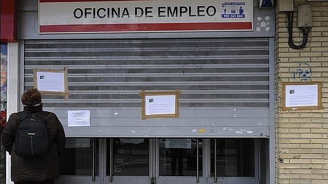 Una mujer frente a una oficina de empleo