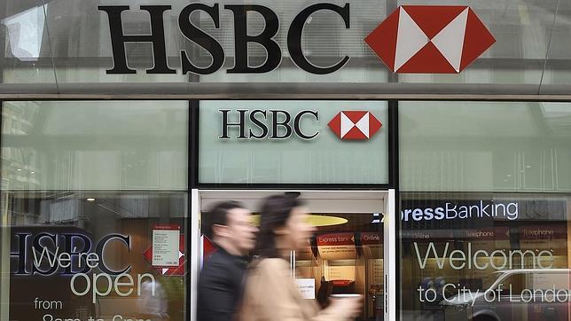 Una pareja camina junto a una filial del banco HSBC en Londres (Reino Unido)