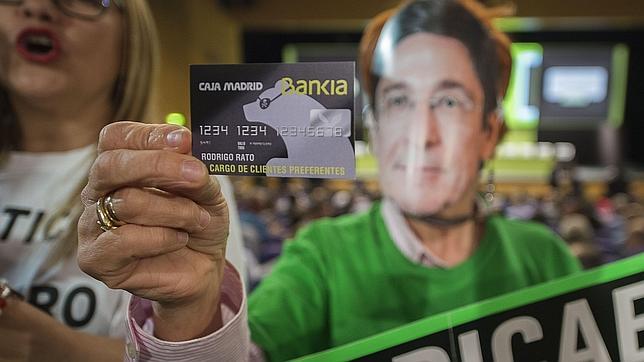 Una preferentista muestra una tarjeta black en la Junta de Accionistas de Bankia de esta semana