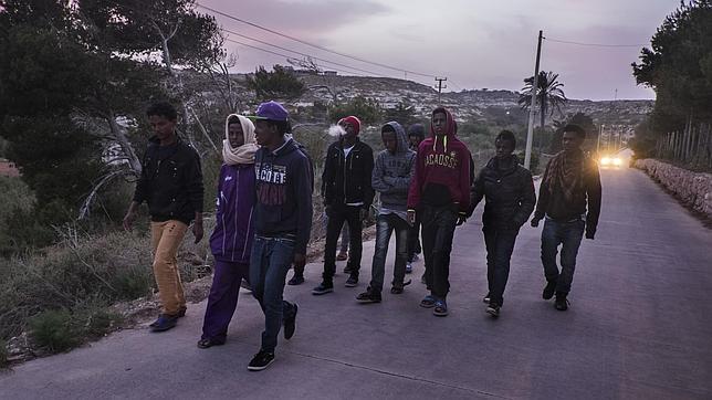 Un grupo de jóvenes inmigrantes eritreos caminan por la isla italiana de Lampedusa días después de haber sido rescatados en aguas del Mediterráneo