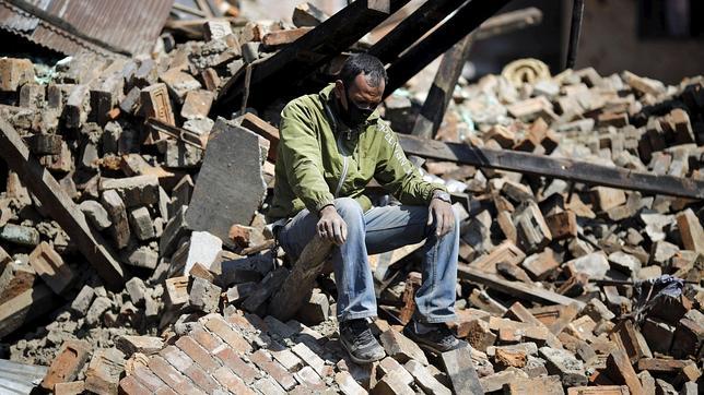 Un nepalí descansa sobre los restos de su casa en Bhaktapur, Nepal