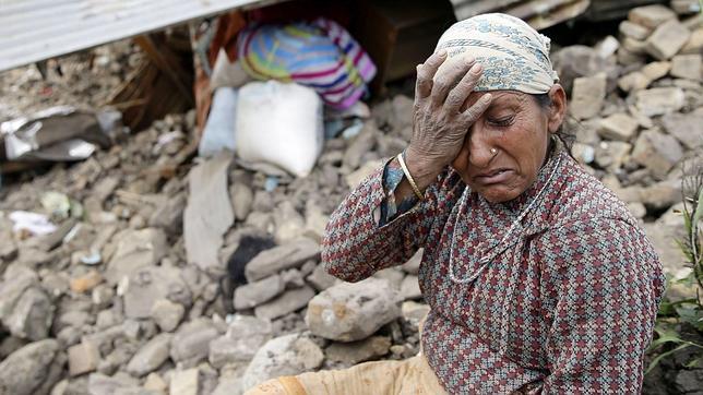 Una mujer se lamenta junto a su casa destruída en la aldea de Kumalpur, a las afueras de Katmandú, Nepal
