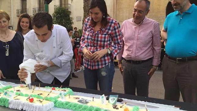 Daniel Patiño trabaja en la elaboración de la tarta ante la mirada de la alcaldesa de Elche