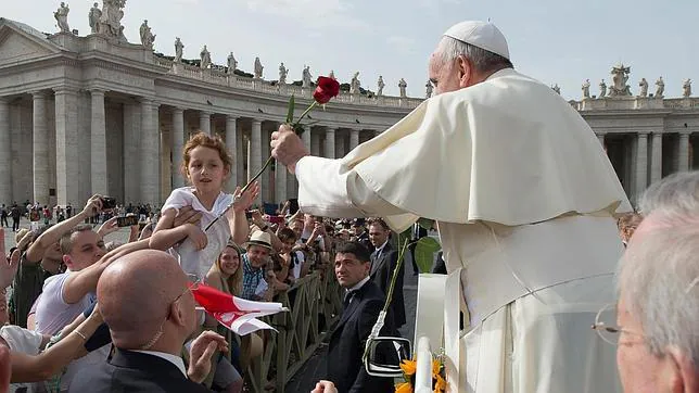 El Papa Francisco recibe una rosa de manos de una niña durante la audiencia pública de los miércoles en la plaza de San Pedro