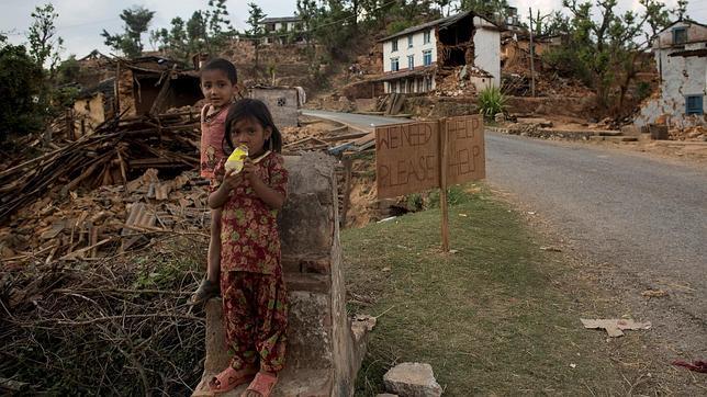 Niños frente a una casa derrumbada en Sindhupalchowk, Nepal