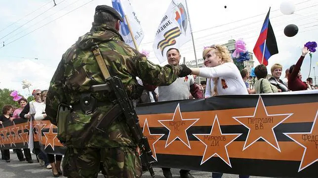 Milicianos prorrusos saludan a un grupo de manifestantes en Donetsk