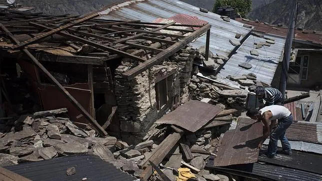 Varias personas tratan de buscar sus pertenencias entre los emcombros causados el terremoto en Katmandú, Nepal