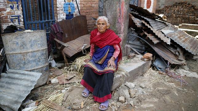 Una mujer descansa sobre los escombros