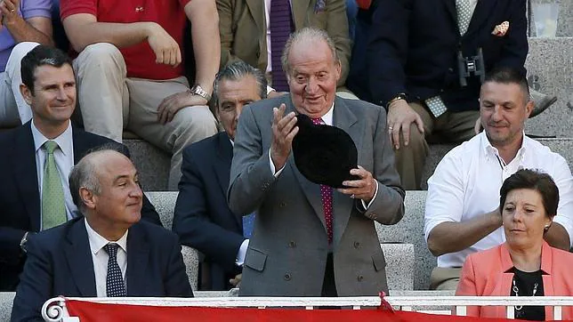 Don Juan Carlos, montera en mano tras recibir un brindis, junto a Fernando Benzo y Carmen del Riego