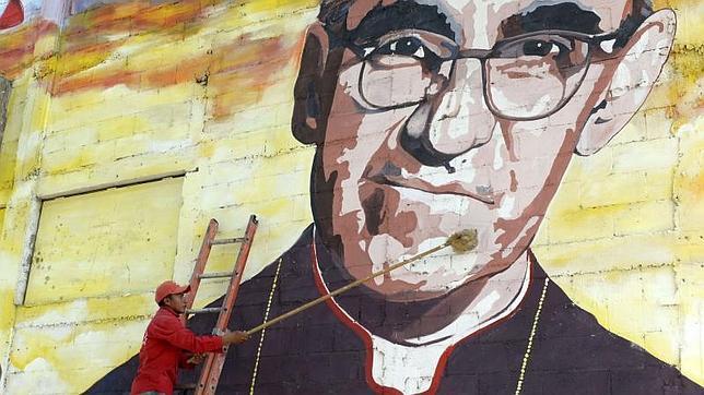 Un hombre limpia un mural de Óscar Romero en Panchimalco, a 20 km. al sur de San Salvador