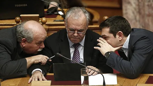 Tsipras habla con el diputado Dragasakis y el ministro del Interior Voutsis en el parlamento en Atenas