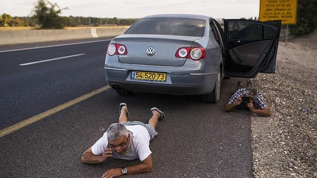 Imagen de archivo que muestra a dos israelíes agachados tras oir las sirenas