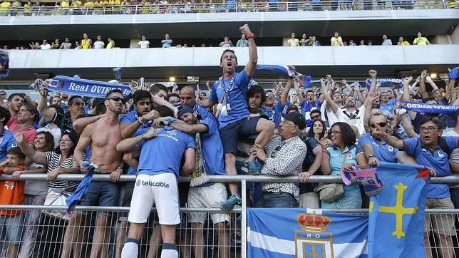 Un jugador del Oviedo celebra el ascenso con la afición asturiana que viajó a Cádiz