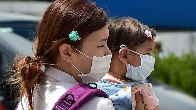 Una mujer y su hija, con mascarillas, en el Hospital Nacional de Seúl