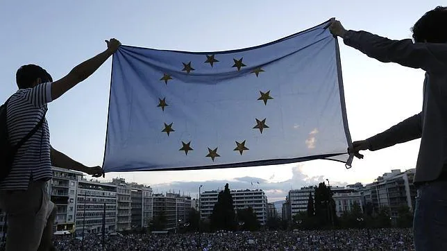 Manifestantes sostienen una bandera de la Eurozona y exigen que Grecia permanezca en la Eurozona a las afueras del parlamento griego en Atenas (Grecia)