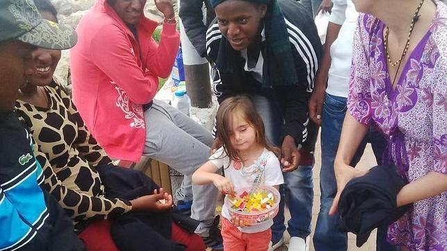 La niña reparte caramelos a los inmigrantes bloqueados en Italia