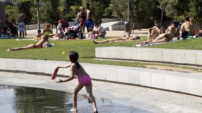 Una niña juega a la pelota en la playa de Madrid