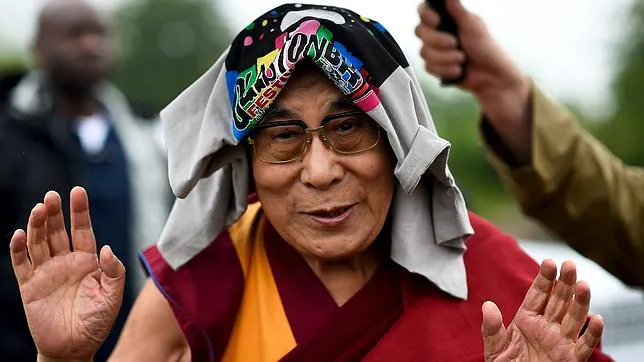 El Dalai Lama se protege de la lluvia con una camiseta de Glastonbury
