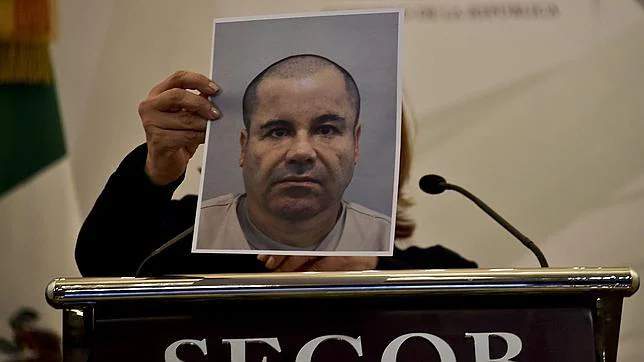 Una policía muestra una foto de Joaquín Guzmán Loera, «El Chapo Guzmán»