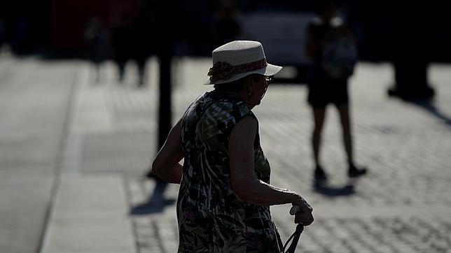 Una anciana da un paseo en un día de altas temperaturas
