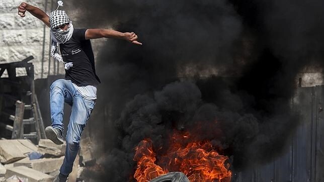Un hombre se enfrenta al ejército israelí durante los disturbios desatados en la localidad cisjordana de Hebrón