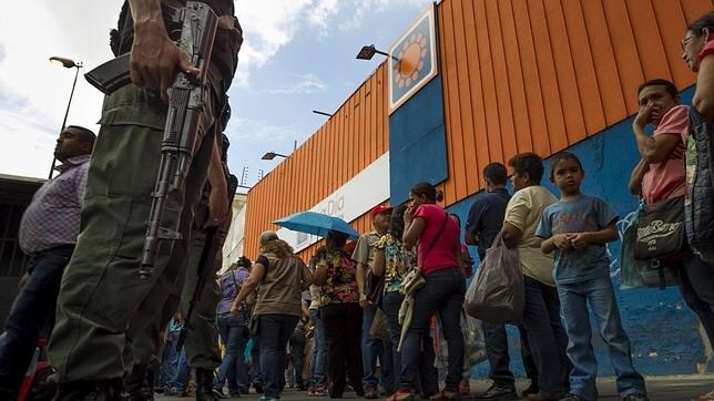La Guardia Nacional vigila las colas de un supermercado en Venezuela
