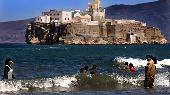 En la imagen, bañistas en la playade Sfiha delante del Peñón de Alhucemas
