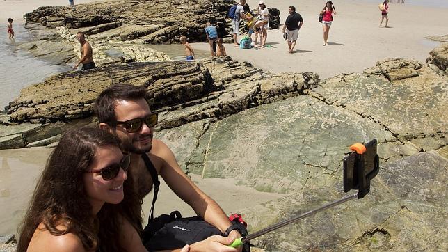 Una pareja se realiza un «selfie» en la playa lucense de As Catedrais