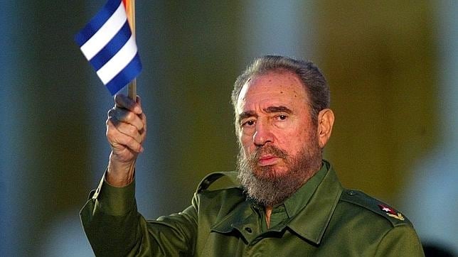 Fidel Castro sostiene una bandera de Cuba durante un acto en 2003