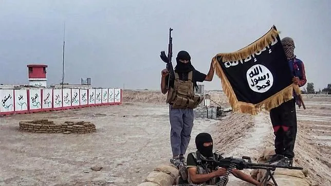 Soldados de Estado Islámico sostienen la bandera del califato islámico terrorista