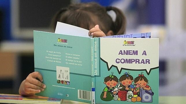 Una niña mira un libro en un colegio de Barcelona