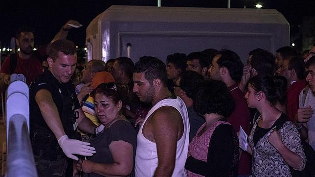 Refugiados sirios esperan para poder embarcar en un crucero reconvertido en alojamiento temporal
