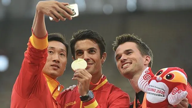 El chino Wang Zhen hace un «selfie» con el campeón Miguel Ángel Lopez y el canadiense Benjamin Thorne en el podio tras la carrera de 20 kms. marcha del Mundial de Pekín