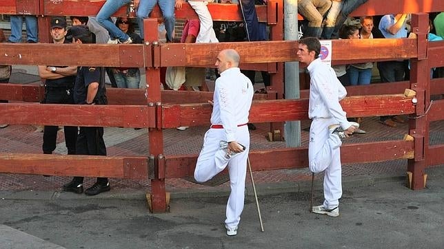Dos personas calientan antes de empezar los encierros de 2011