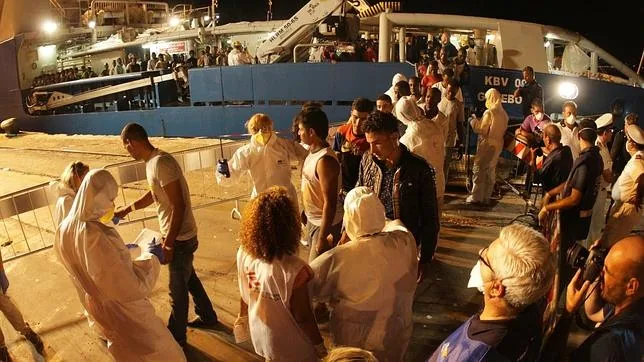 Un grupo de inmigrantes desembarca en el puerto de Palermo después de ser rescatados