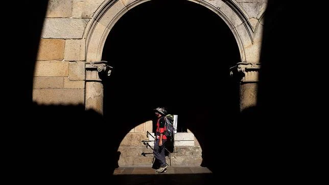 Un peregrino transita por una de las calles de Santiago al terminar el Camino
