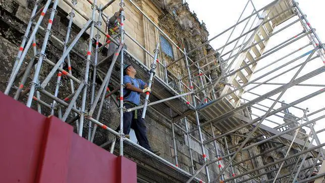 Un operario coloca andamios durante la restauración de la Catedral de Santiago