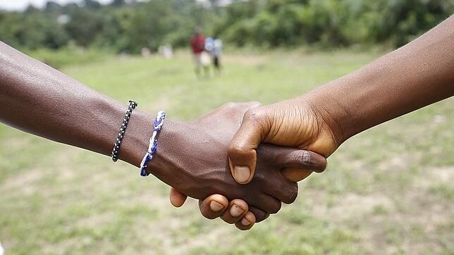 Ciudadanos de Liberia, país vecino a Sierra Leona, estrechan sus manos este 27 de agosto después de que se haya levantado la prohibición de estrecharse las manos para evitar contagios