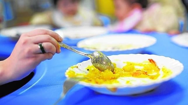 Una mujer da de comer a sus hijos en casa