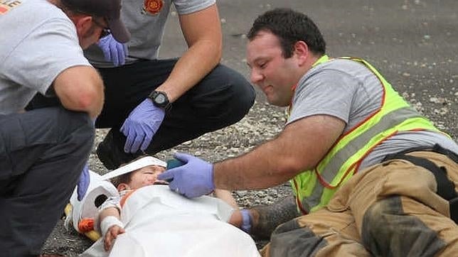 Un bombero calma a un niño, víctima de un accidente, con una película de dibujos animados