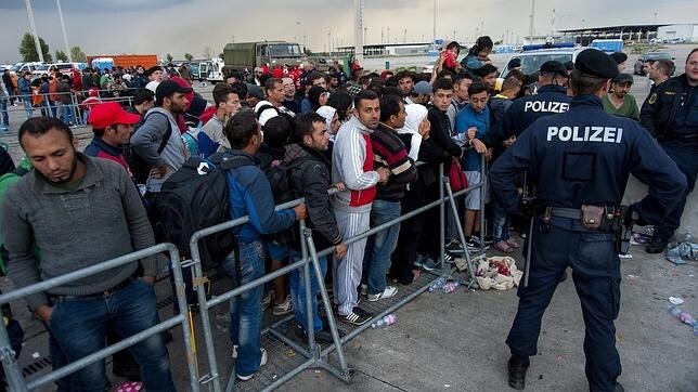 Migrantes procedentes de Hungría esperan un bus en la frontera con Austria, en Nickelsdorf, ayer. La oleada de refugiados que ven en Hungría la puerta de entrada para solicitar asilo en Europa Occidental no se reducirá en las próximas semanas.