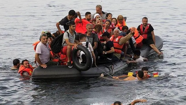Varios refugiados sirios llegan en una lancha neumática a la costa de Mitilene en la isla de Lesbos, Grecia