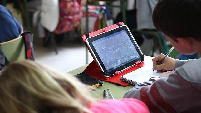Un grupo de alumnos estudia con una tablet en el aula