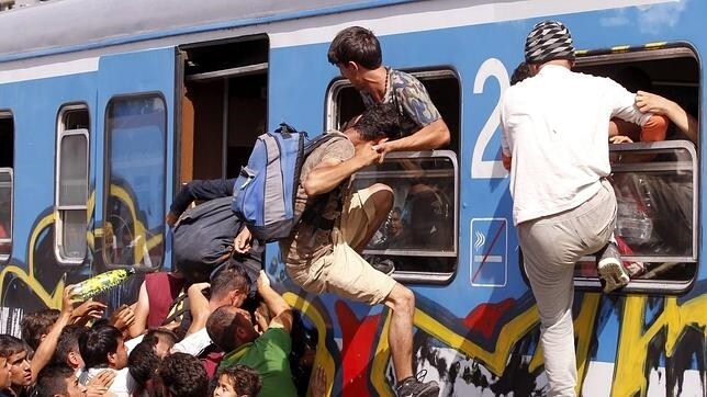 Refugiados se empujan entre sí para subir a bordo de un tren rumbo a Zagreb en la estación de Beli Manastir
