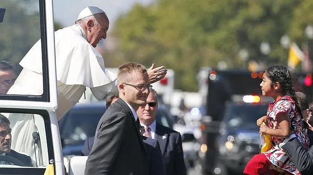 MOmento en el que un agente de seguridad aupaba a la niña hacia el Papa Francisco