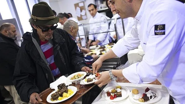 Un hombre recibe alimento en un comedor social madrileño