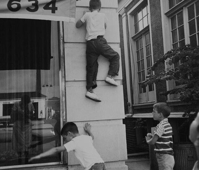 Vivian Maier fotografía su reflejo mientras unos niños juegan a su alrededor en Chicago