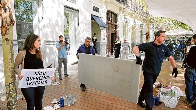 Una empleada se encadena en la terraza del restaurante Ramsés, frente a la Puerta de Alcalá, para evitar su cierre